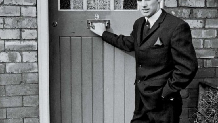 1964 г., "Ейклиф Авеню" в Манчестър
Скаутът на Юнайтед - Боб Бишъп го забелязва още на 15 и праща телеграма на Мат Бъзби със съдържание: "Мисля, че намерих гений". Бести идва на проби, но само два дни по-късно си тръгва, тъй като тъгува за дома. Бъзби обаче се свързва с родителите му и го връща в Англия. Тук е пред първата си квартира в Манчестър, където живее с Дейвид Седлър. По времето на снимката вече е титуляр и звезда в града. През 1969-а купува първата си къща.