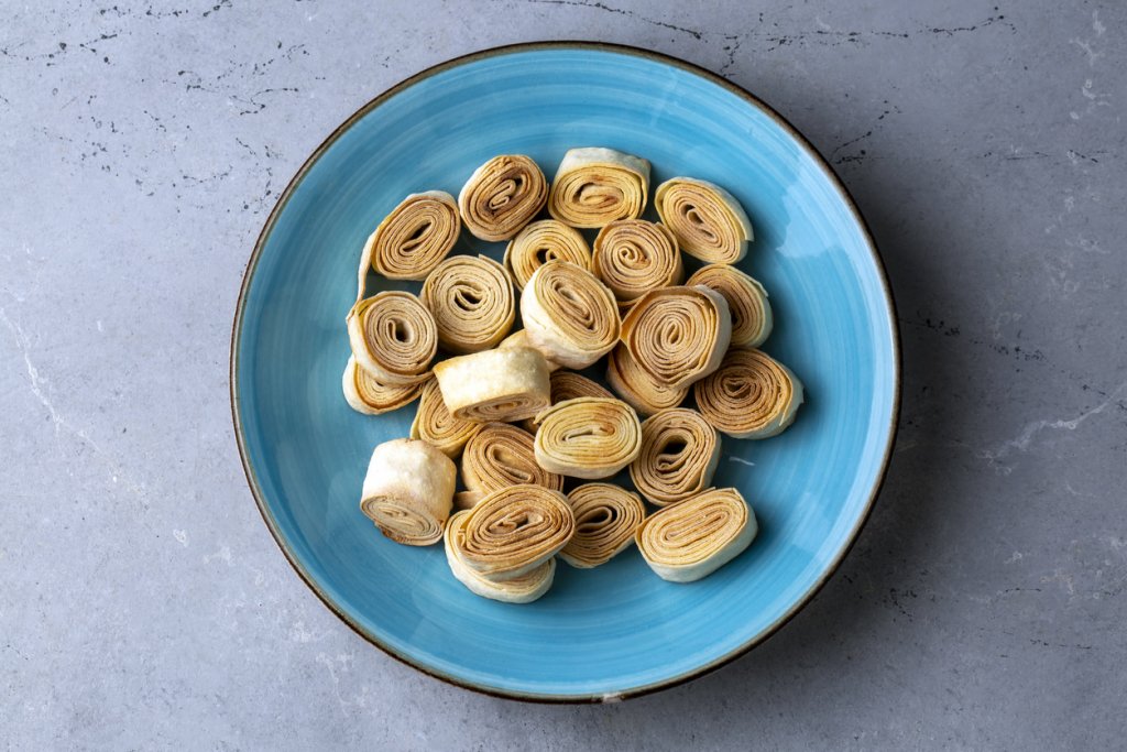 Хрупкави сладки "охлювчета"Тези „охлювчета“ са бързи, лесни и ще станат любимо сладко похапване на всеки у дома. Корите за баница се режат на ленти и се завиват на спирали. Намасляват се с разтопено масло и се поръсват със смес от захар и канела. Пекат се на 180 градуса до приятен загар.
Към поръската може да се прибави ванилия, малко карамфил или други подправки на вкус. „Охлювчетата“ могат и да се сиропират за още по-апетитен завършек.