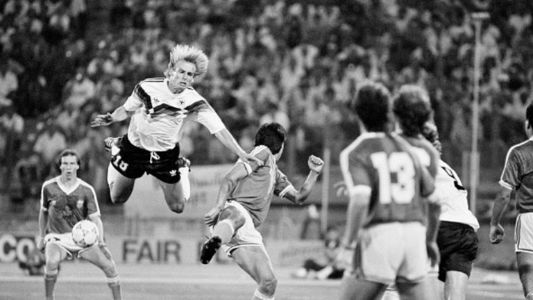 В царството на мръсните номера

Смело може да се каже, че световното първенство през 1990 г. в Италия се явява истинско царство за майсторите на мръсните номера. Циничният футбол с едва 2.21 средно гола в мач е съчетан с ред измамни изпълнения. Както си му е редът, връх на всичко е финалният двубой между Германия и Аржентина. В 65 минута Юрген Клинсман затвърждава репутацията си на футболен мошеник, когато прави невероятно изпълнение на „умиращия лебед”. С падането си той успява да подлъже съдията Едуардо Мендес, който показва на аржентинеца Монсон първия червен картон във всички дотогава световни финали. Не по-малко скандално се явява падането на Руди Фьолер след контакт рамо в рамо с Роберто Сенсини. Минутата е 85-та, а реферът отсъжда дузпа. Андреас Бреме я вкарва, за да донесе титлата на Германия. Още по-смешно става при връчването на наградите. Обявеният за носител на приза за феърплей Гари Линекер отива да стисне ръката на Юрген Клинсман. „Цяло чудо е, че Клинсман не падна при това ръкостискане!”, отбелязва иронично коментаторът на английската телевизия.