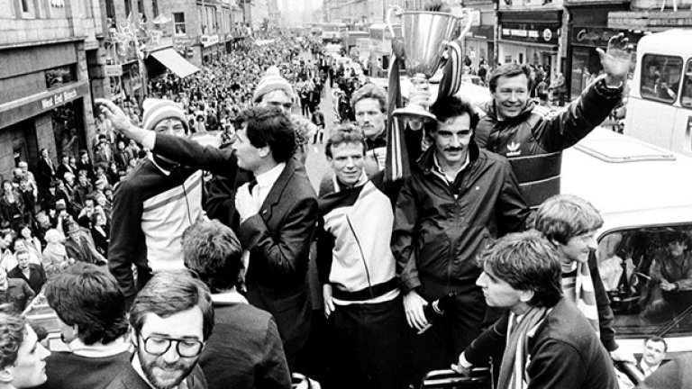Капитанът на Абърдийн Алекс Маклийш гордо е вдигнал КНК на парада по улиците на града след знаменития триумф над Реал Мадрид в Гьотеборг. Вдясно е мениджърът Алекс Фъргюсън. Успехът срещу Реал на Ди Стефано е един от великите в бляскавата кариера на шотландеца. След 8 хубави години при "доновете" Фърги се премести да пише история в Манчестър Юн., където остана цели 27 сезона.