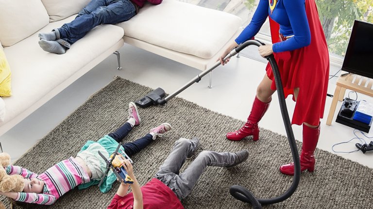 Superhero vacuuming around family in living room