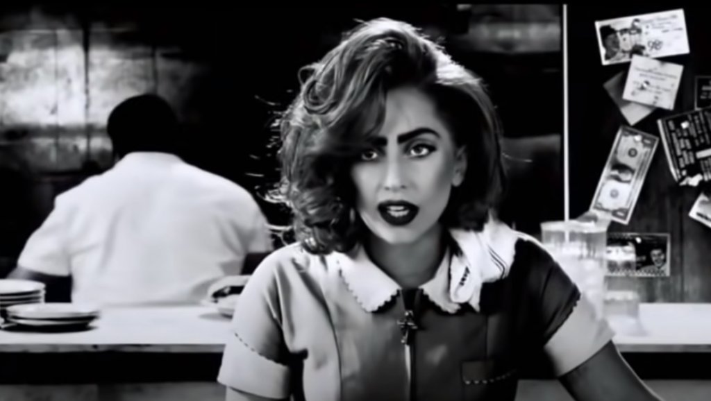 “Град на греха: Жена, за която да убиеш”
Малка, но забележителка е ролята на Гага в “Град на греха: Жена, за която да убиеш”. Изпълнителката влиза в ролята на сервитьорка, която посреща с чаша вода размазания от бой Джоузеф Гордън-Левит.
След кратък разговор героинята на Гага дава един долар на героя Левит.
“Тя е фантастична актриса. Не знаех това. Когато дойде, си помислих: “Добре, искат голяма поп звезда във филма, разбирам”. Но когато започна да играе, ме разби”, казва Джоузеф Гордън-Левит за участието ѝ.