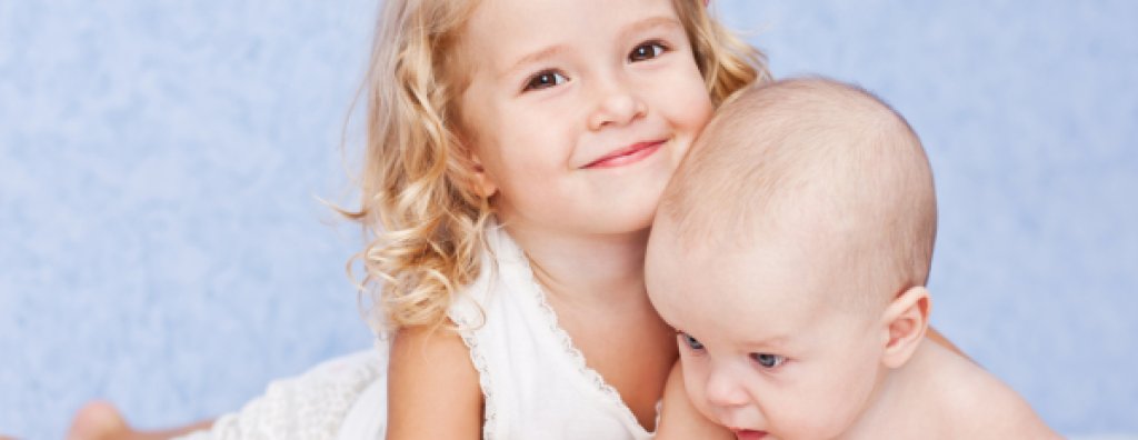 happy sister hugging baby brother