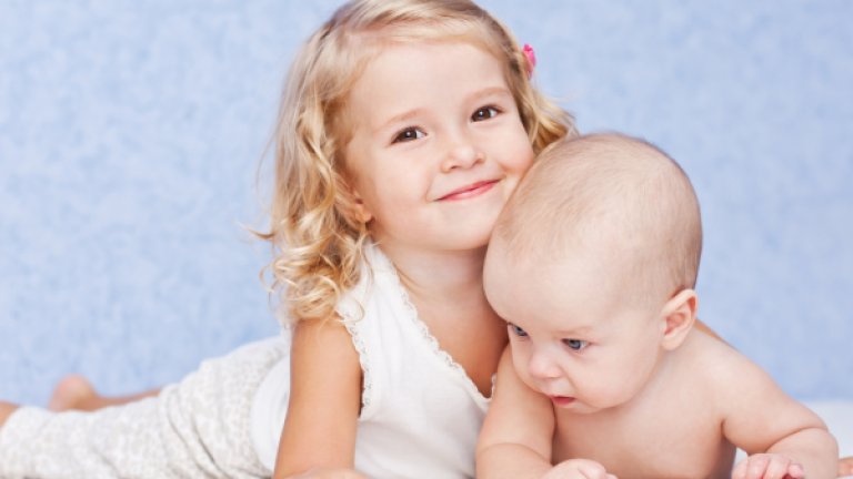 happy sister hugging baby brother