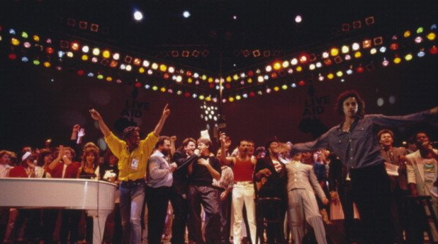 На тази снимка са Джордж Майкъл, Боно, Пол Маккартни, Фреди Меркюри и Боб Гелдоф. 
Датата е 13 юли 1985г., а мястото стадион "Уембли" - благотворителен концерт за децата в Етиопия.