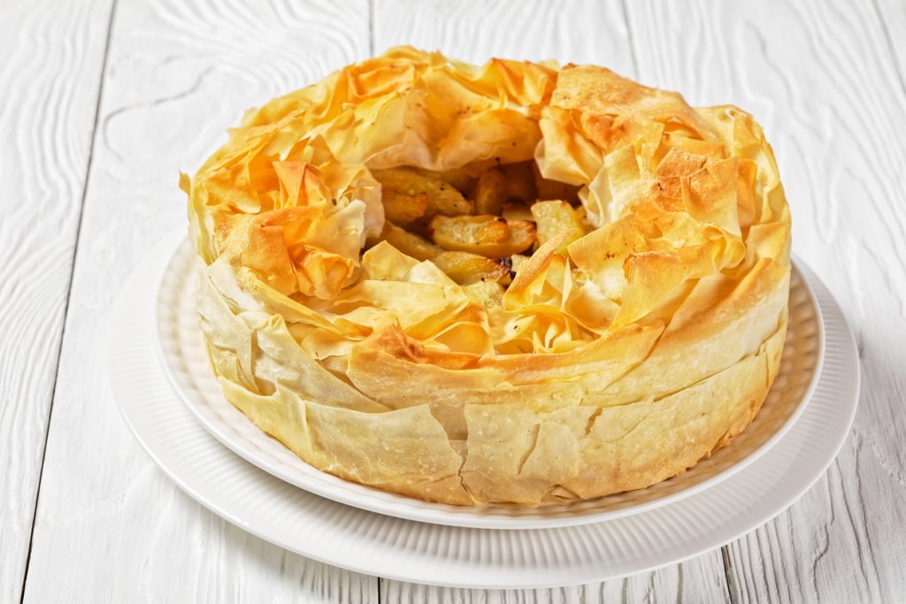 Нещо като тарт "Татен"Тарт „Татен“ се приготвя с маслено тесто, но нищо не пречи да го използваме като вдъхновение за друг десерт. Около 500-600 грама ябълки се белят, почистват и режат на едри кубчета. В дълбок тиган с малко масло се запържват ябълките с лъжица канела, лъжица кафява захар и малко ром. След като алкохолът се изпари, плодовете се отстраняват от котлона.
На дъното на намаслена тава се редят пет кори, като между тях мажем с малко разтопено масло. Краищата на корите трябва да излизат от тавата. Изсипват се ябълките и другите кори от пакета се накъсват и намачкват, след което се оформят на венец над плодовете. Пече се на 180 градуса.