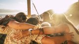Teamwork and friendship concept for people outdoor hugging all together with love and friends lifestyle - happiness and relationship with group of females having fun - ocean view