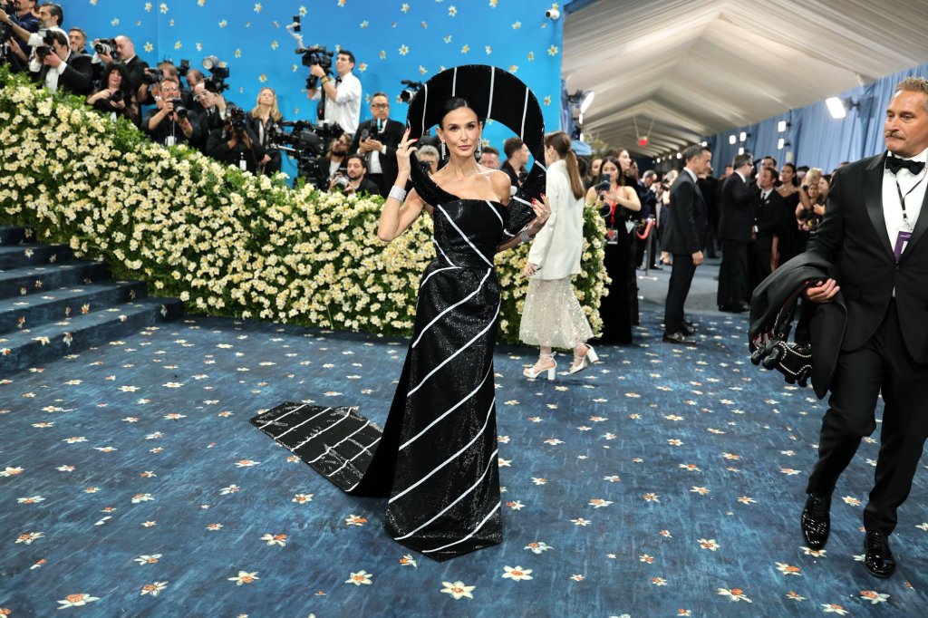 Деми Мур беше в черно-бяла рокля на Thom Browne, вдъхновена от формата на мъжка вратовръзка. Горната част наподобява възел на вратовръзка, а долната - дължината. Основният аксесоар беше структурната халка около главата, напомняща на абстрактна шапка.