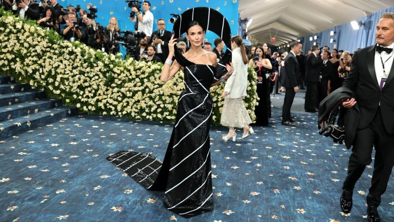 Деми Мур беше в черно-бяла рокля на Thom Browne, вдъхновена от формата на мъжка вратовръзка. Горната част наподобява възел на вратовръзка, а долната - дължината. Основният аксесоар беше структурната халка около главата, напомняща на абстрактна шапка.