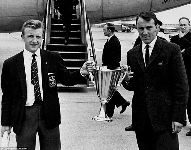 Тери Дайсън и Джими Грийвс от Тотнъм показват КНК при завръщането си в Англия след разгрома с 5:1 над Атлетико Мадрид на финала в Ротердам. И двамата бележат по два гола за убедителния успех на лондончани през 1961 година. "Шпорите" се радваха на страхотни времена, след като европейският им успех бе последван от шампионска купа и две титли от ФА къп - през 1961 и 1962.