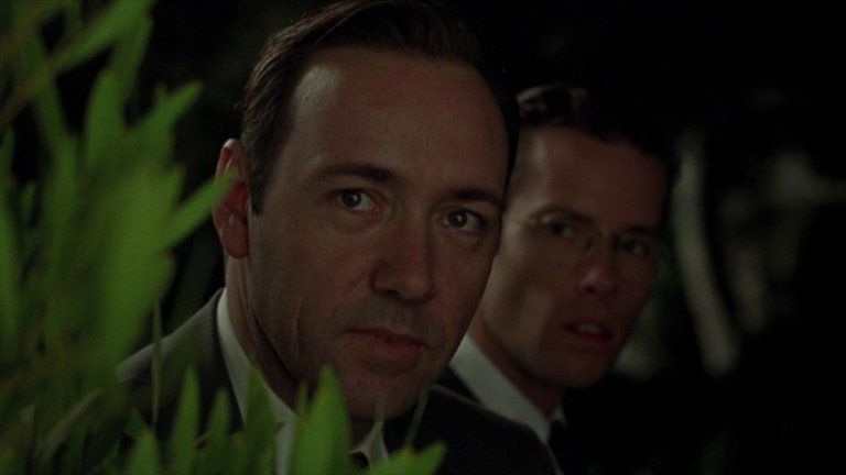 Образът на Спейси е културен архетип на Ел Ей от 50-те. Корумпирано ченге-звезда и консултант на полицейски тв сериал, който „урежда" холивудски арести и търгува информация с таблоидно списание за сензации, пикантерии и клюки