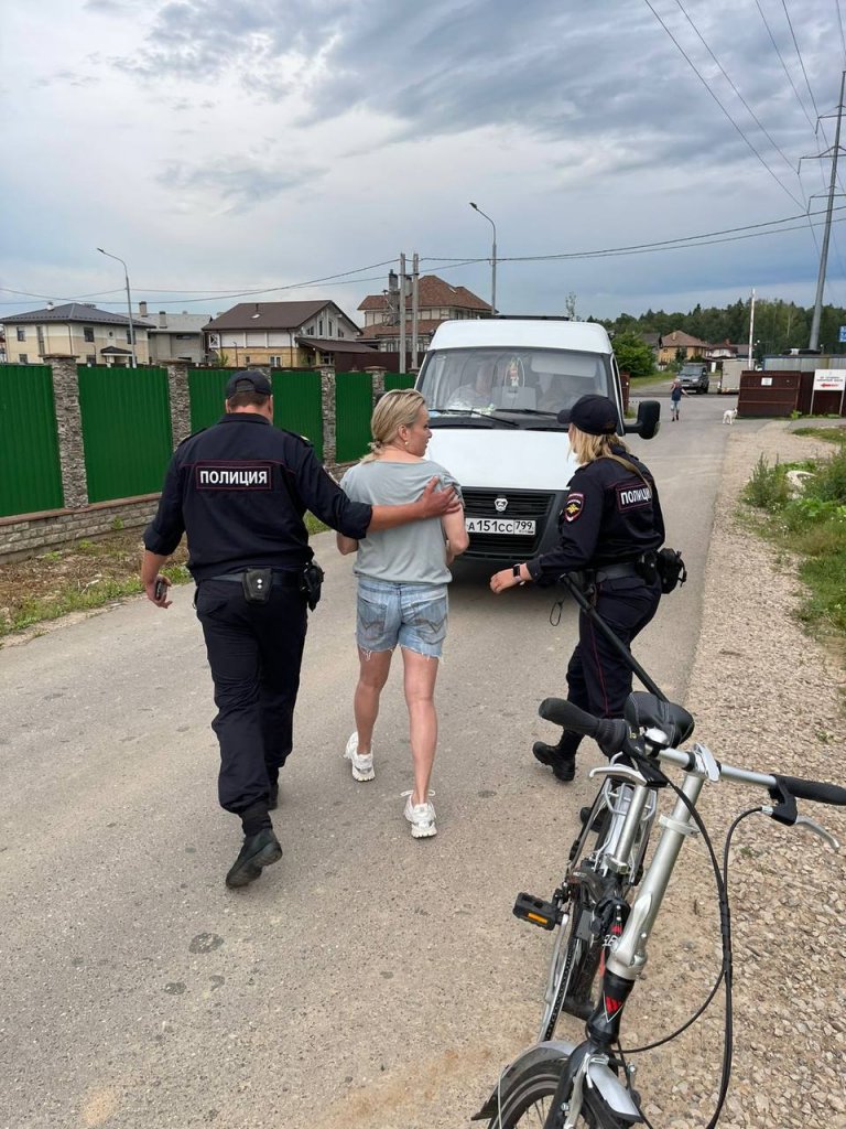 Марина Овсянникова бива откарана в бял бус от полицаи.