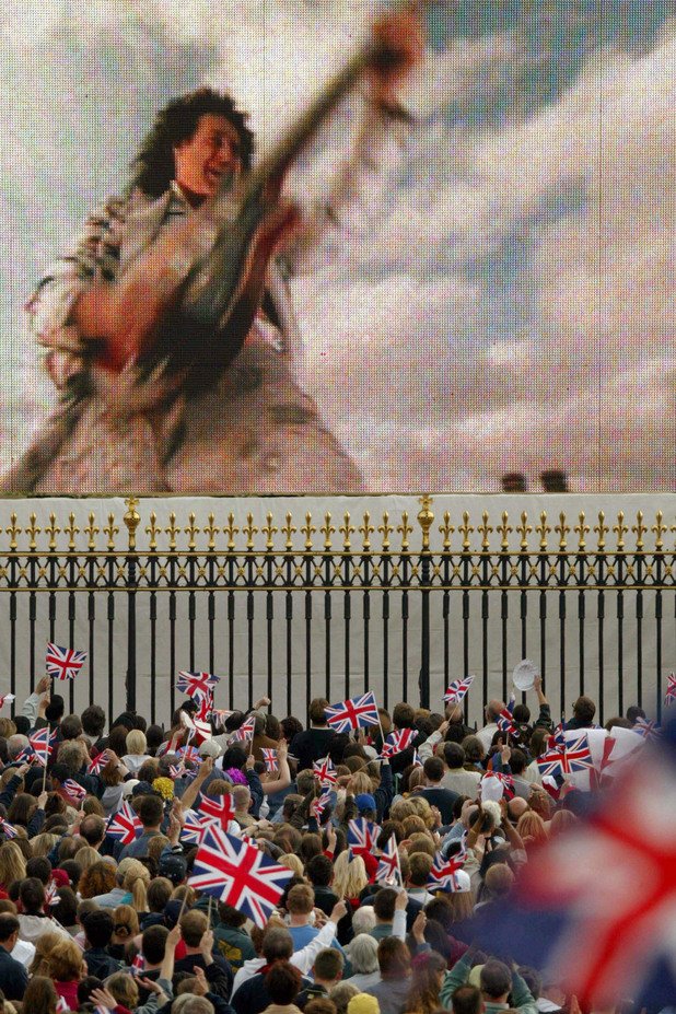 Огромна видеостена показва как Мей свири английския химн на покрива на Бъкингамския дворец на златния юбилей на Queen през 2002 г.