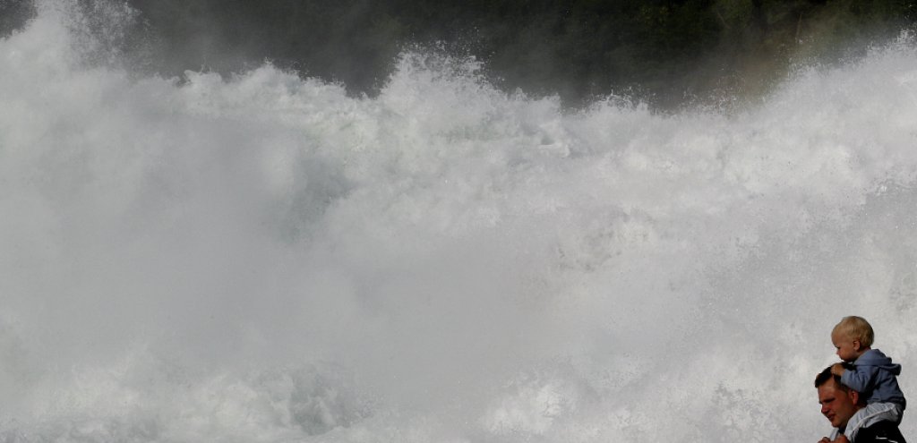 Tourists look at the Rhine Falls in the town of Neuhausen