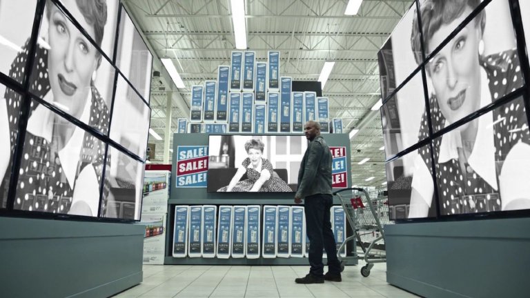 Невероятната Джилиън Андерсън променя лика си като хамелеон, влизайки от един попкултурен образ в друг. Тя е Медиа – въплъщение на съвременните медии.