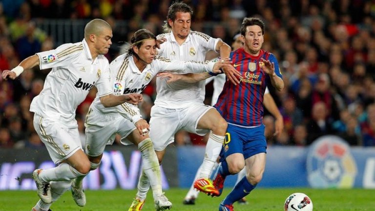 Класика в Ел Класико - трима нахъсани играчи в бяло опитват да спрат магьосника в синьо и червено.