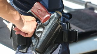 A woman with a Macarov gun in a black holster.