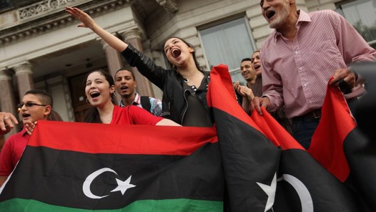 Либийци ликуват пред посолството си в Лондон, след като бунтовниците превзеха Триполи.