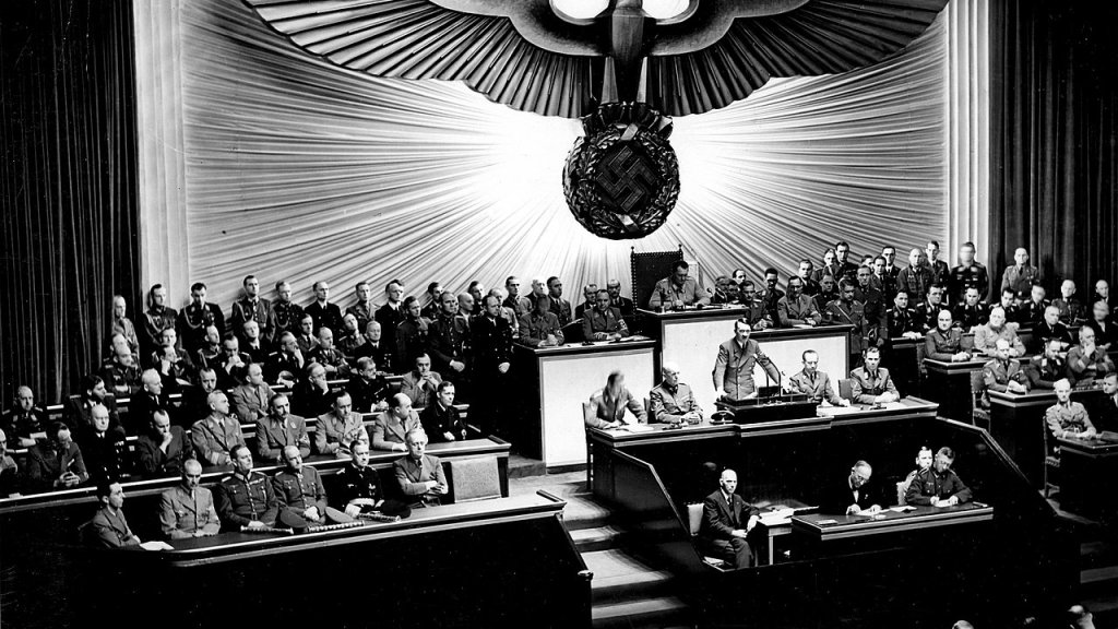 1280px-Bundesarchiv_Bild_183-1987-0703-507,_Berlin,_Reichstagssitzung,_Rede_Adolf_Hitler