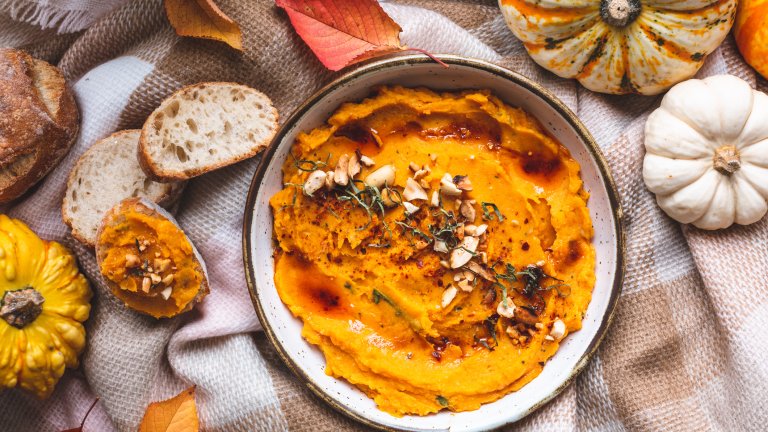 Тиквен дипПо-лека, а и много бърза вечеря, за която белим и режем на парчета една средна към голяма тиква. Сорт – по избор. Редим в тава, застлана с хартия за печене, поръсваме със сол, черен и червен пипер, ръсим със зехтин и запичаме на 180 градуса до покафеняване на крайчетата. Изсипваме в дълбока купа.
Добавяме 220 грама крема сирене, 150 грама жълто сирене – грюер, кашкавал, пармезан – и малко бекон на ситно. Можем да добавим и лук, чесън, малко тахан, и подправяме отново на вкус със сол и пипер. Поднасяме с препечен хляб, крекери или тортила чипс.