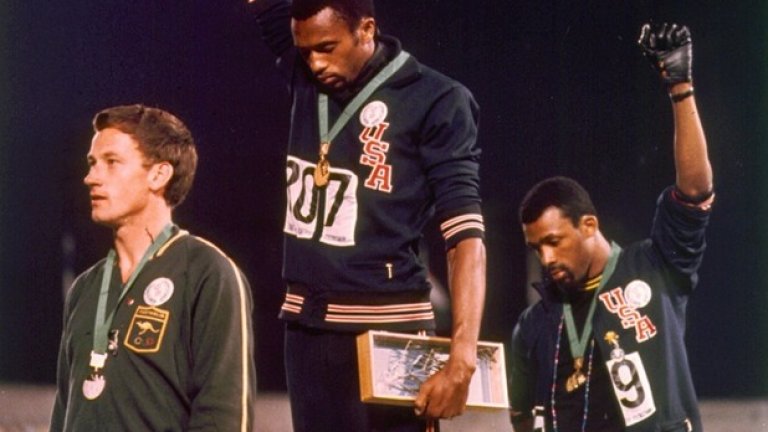 По време на Олимпийските игри през 1968-ма в Мексико Сити, фотографът Джон Доминис прави тази легендарна снимка на американските атлети Томи Cмит и Джон Карлос, които вдигат ръце по време на награждаването си. Те протестират срещу отношението на обществото към афроамериканците.
  Двамата медалисти стоят с наведени глави по време на изпълнение на американския химн. По-късно тази поза става известна като поздрава на "Черната сила" (Black Power). 
 Смит и Карлос твърдят, че в жестовете им не е имало нищо предизвикателно. Въпреки това Международният олимпийски комитет ги дисквалифицира, заради нарушаване на спортните правила чрез политическа агитация