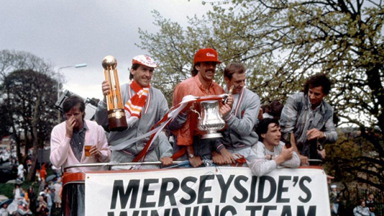 Ливърпул вероятно е имал и по-добри отбори от този през сезон 1985/86, но тогава за първи и единствен път в историята си постигна дубъл от шампионска титла и ФА къп. На снимката играещият мениджър Кени Далглиш държи шампионската купа, а неговият съотборник Марк Лоурънсън е с трофея от ФА къп. Останалите футболисти на "червените" са Рони Уилън, Алън Хансен и Крейг Джонстън. Далглиш реализира победния гол срещу Челси в последния кръг и осигури златото в първенството, а на финала за Купата Ливърпул навакса изоставане от градския си съперник Евертън и успя да го победи.