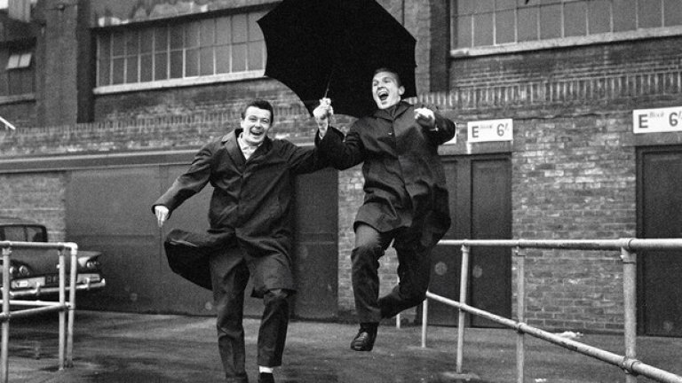 Джон Бирн и Боби Муур пеят в дъжда пред стадион "Ъптън Парк", дома на Уест Хем. Клубът от Източен Лондон дава четирима основни играчи на тима, спечелил световната купа. Включително капитана Муур и голмайстора на хеттрик на финала Хърст.