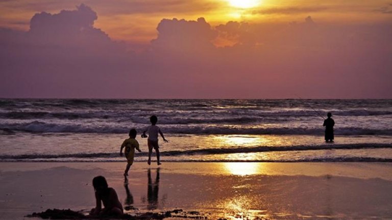 Безгрижни игри по залез в Кута, Бали. Рибарите се възползват от липсата на сърфисти, което е доста рядко явление по тези места.