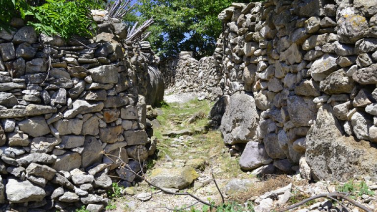 Калдъръмените улички на Ненково се вият покрай високите каменни зидове на селските дворове.