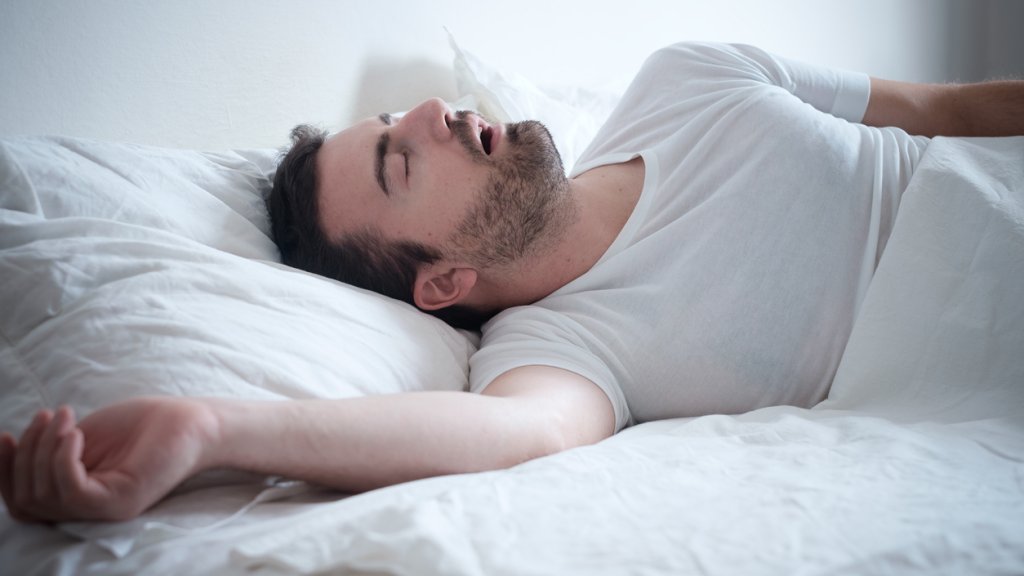 Man sleeping in his bed and snoring loudly