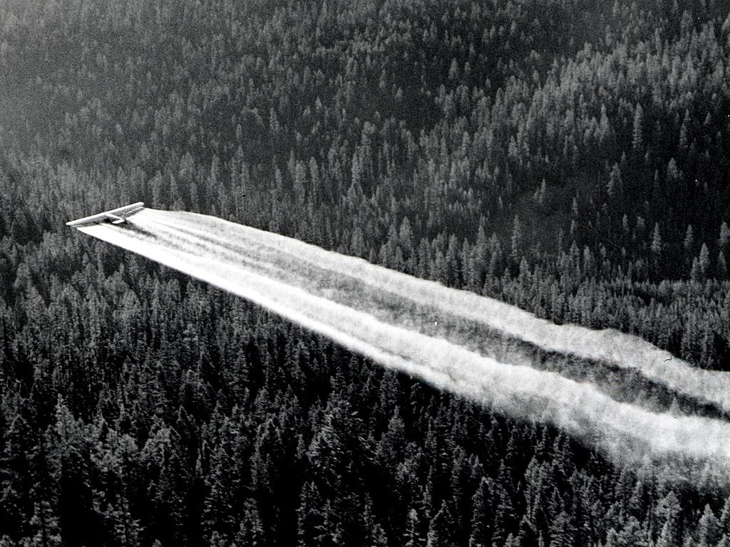 1955._Ford_tri-motor_spraying_DDT._Western_spruce_budworm_control_project._Powder_River_control_unit,_OR._(32213742634)