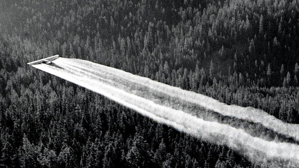 1955._Ford_tri-motor_spraying_DDT._Western_spruce_budworm_control_project._Powder_River_control_unit,_OR._(32213742634)