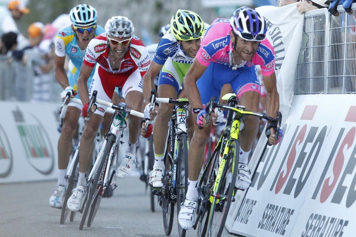 6. Почитането на Микеле Скарпони 
Дни преди старта загина шампионът от 2011 г. Микеле Скарпони. Един от най-силните италиански катерачи през последното десетилетие има още три победи в престижни многоетапни състезания: Тиренто-Адриатико през 2009 г., Обиколката на Каталуня и Обиколката на Алпите през 2011 г.