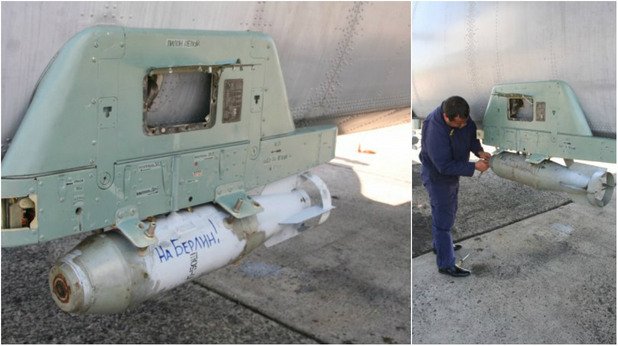 На снимките от ученията на руския ВМФ се виждат стар военно-транспортен самолет Ан-26 с крепеж за снаряд, върху който е добавен надпис на руски "Към Берлин!" и "За Сталин!"