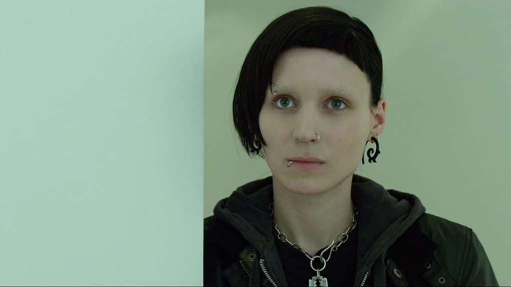 "Мъжете, които мразеха жените" (The Girl with the Dragon Tattoo)Година:2011Едноименният криминален роман на Стиг Ларшон е перфектен повод за Финчър да се върне към поджанра "кино за серийни убийци" със своя девети филм.Фокусът обаче пада и върху отношенията между разследващия журналист Микаел Бломквист (Даниел Крейг), нает от богаташ да разследва случай с давност от 40 години, и умна хакерка с тъмно минало (Руни Мара), която му става асистент.Двамата попадат в заешка дупка, погълнала много герои на Финчър, а както обикновено, и тук паралелно с ровенето в чуждите престъпления, те се борят и със собствените си травми и обсесии.