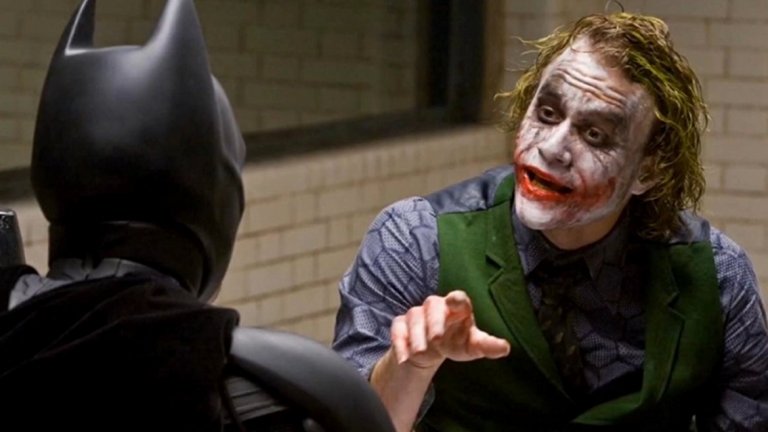 4. Хийт Леджър (The Dark Knight, 2008)
"Не съди книгата по корицата" важи в пълна сила тук. Когато стана ясно, че Хийт Леджър ще играе Жокера в "Черният рицар" на режисьора Кристофър Нолан, много фенове имаха своите съмнения. Леджър обаче изуми публиката с невероятното си превъплъщение, което може би коства и живота му. Пълната му отдаденост, за да пресъздаде "своя" Жокер му донесе и посмъртно награждаване с "Оскар" за най-добра поддържаща роля. Образът се превърна и в попкултурен феномен, а за повечето съвременни зрители "друг Жокер няма".
Тук персонажът е по-различен. Усмивката му се дължи на белези, за чиито произход той постоянно си измисля различни истории. Облича се по-театрално, но не така "клоунски" като другите версии. Бялото му лице и зелената коса са плод на грим, а не на инцидент с химикали. В същото време е може би най-нестабилната версия от всички - анархист и терорист, способен да изгради изключително сложни планове, макар да твърди, че няма такива; винаги въоръжен с няколко ножа в себе си и твърде склонен да ги използва.