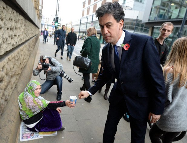 Лидерът на Лейбъристите Ед Милибанд дава пари на просеща жена, докато отива на среща на британските лидери на 31 октомври 2014 година. Скорошно социологическо проучване е показало, че Лейбъристите вероятно ще загубят местата си в Шотландската национална партия следващата година.