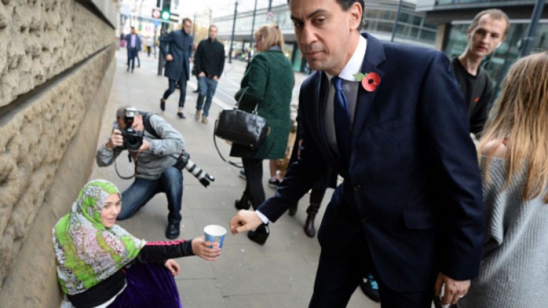 Лидерът на Лейбъристите Ед Милибанд дава пари на просеща жена, докато отива на среща на британските лидери на 31 октомври 2014 година. Скорошно социологическо проучване е показало, че Лейбъристите вероятно ще загубят местата си в Шотландската национална партия следващата година.