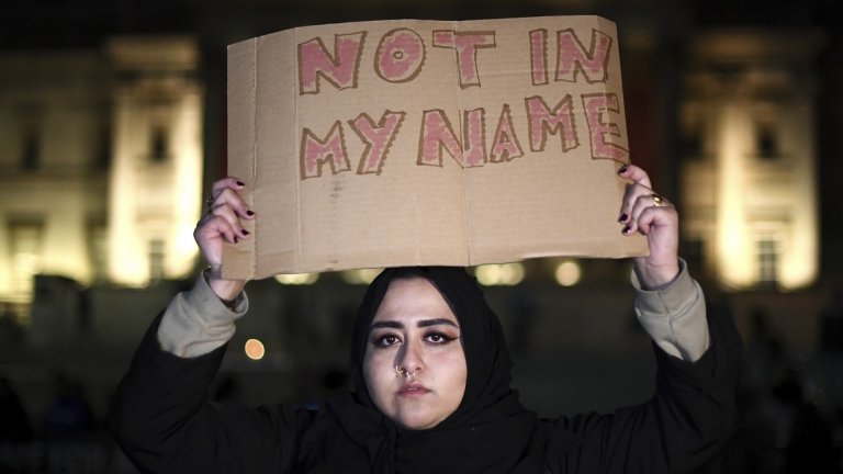 "Не в моето име", пише на плакат, носен от жена със забрадка, за да покаже, че атентатите не са в името на мюсюлманите