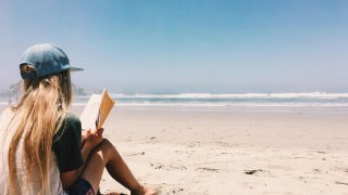 момиче чете книга, книги, лято, слънце, море, плаж, вълни, пясък, почивка, ваканция