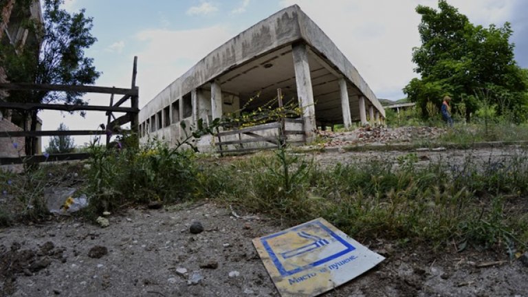 Табелка, отдавна изгубила значението си, лежи захвърлена на земята пред сградата на кухнята