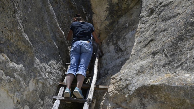 Достъпът до изсечената в скалите пещера става чрез малка дървена стълба.