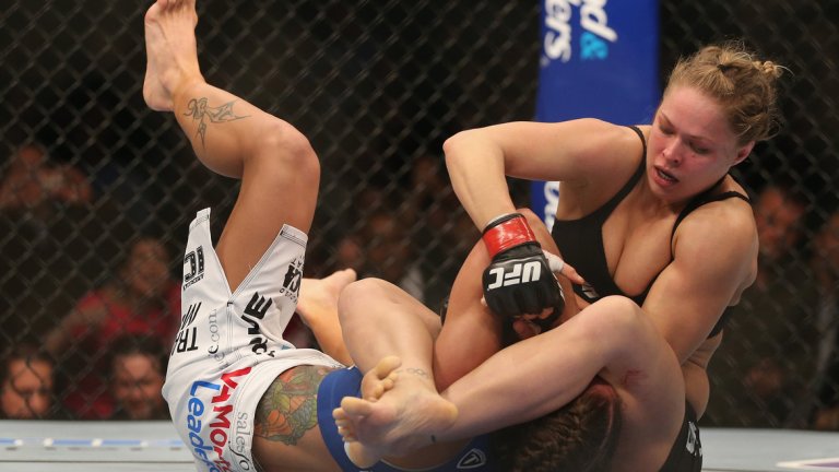 2. Дебютът в UFC
По-малко от две години след като Дейна Уайт каза, че „никога“ не би вкарал жени в UFC, категорията до 61 кг бе представена. Ронда Раузи бе обявена за временната шампионка, а първият женски двубой в организацията бе между нея и Лиз Кармуш в UFC 157 на 23 февруари 2013 г. След като издържа на ключа на Кармуш рано в мача, всички знаеха какво да очакват. Ронда я подготви, взе й ръката и нова победа с армбар в първи рунд.