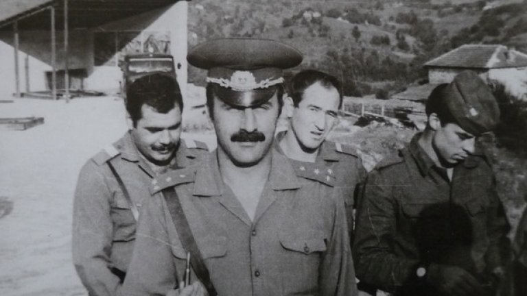 80-те години. Офицери и войници от поделението в родопския град по време на учебни стрелби. На заден план - част от навеса за танковете и все още ясно различимите илюстрации на видовете танкова стрелба