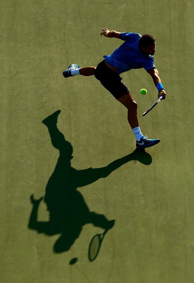 Григор Димитров се гони със сянката си, за да върне топката в мача срещу Райън Харисън на US Open.