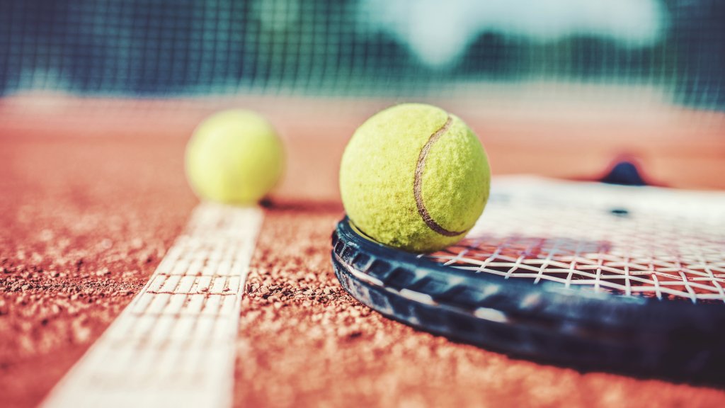 Tennis ball with racket on the tennis court. Sport, recreation concept