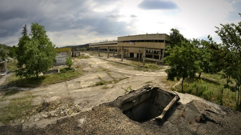 Ръждивите останки от някогашна постройка и обраслият с трева асфалт превръщат двора в истински постапокалиптичен пейзаж