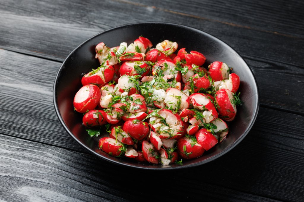 Репички с бекон и подправкиРепичките често са добавка към други продукти, а могат да са впечатляваща гарнитура. Почистваме и измиваме две връзки репички, като по-големите режем на две. В нагорещен тиган запържваме една глава лук и шепа бекон, прибавяме репичките и леко ги намачкваме, за да си пуснат сока. След това добавяме на ситно магданоз и чесън, сол, черен пипер и оцет. Разбъркваме и сервираме топли.