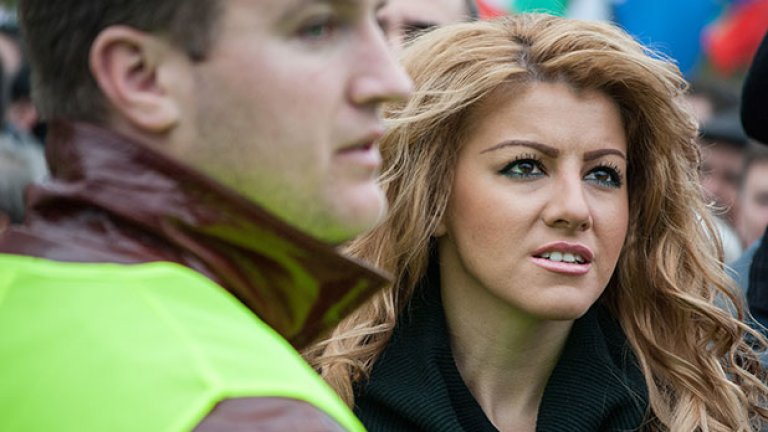 Красива и празнично облечена девойка гледа с плам в очите представителите на БСП, качени на подвижната сцена.