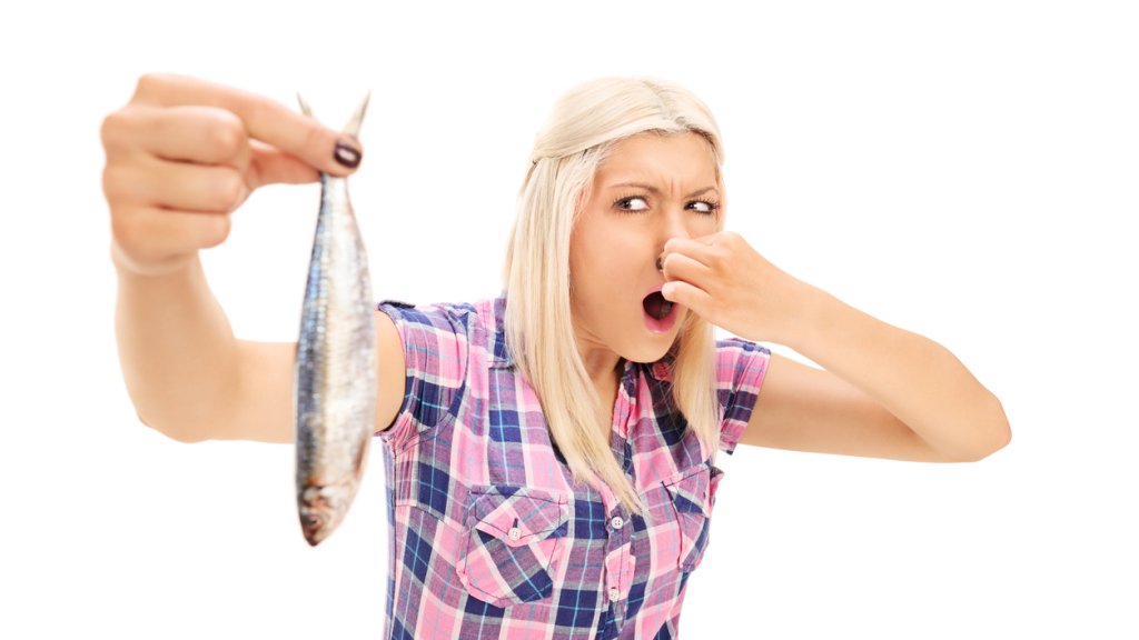 Blond woman holding a stinky fish